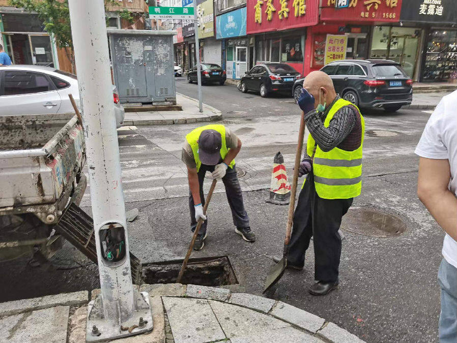 维护人员正在清掏雨水井(张洪超 摄)勇于担当,落实防汛值班制.