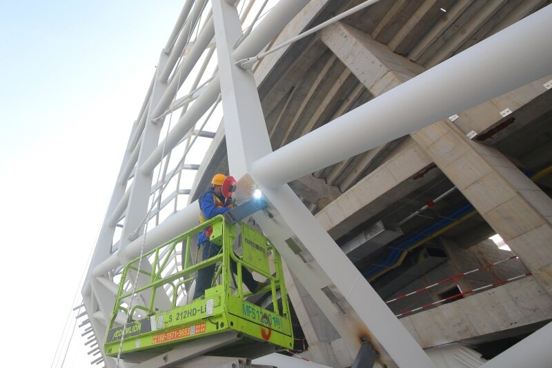 山东青岛亚洲杯青岛青春足球场施工现场,工人正在进行金属幕墙基层