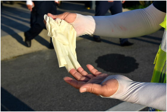 图为一名交通防疫工作人员脱下防护手套时,手掌被汗水浸泡得发白(胡