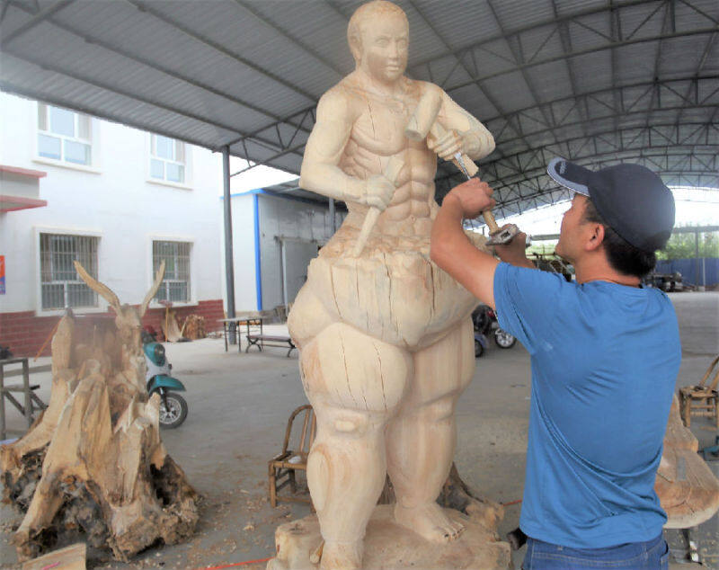 图为木雕师傅在雕刻工艺品(颜寿林 摄)