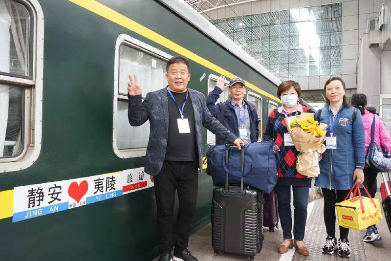 图为整装待发的上海游客在旅游专列前合影留念（王雪娇 摄）