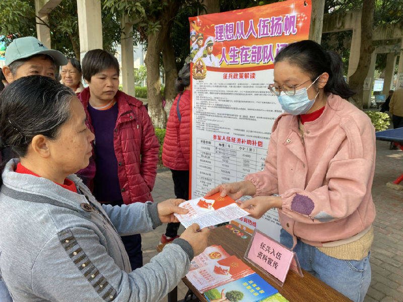 图为社区工作人员向居民进行征兵宣传(麦子艳 摄)