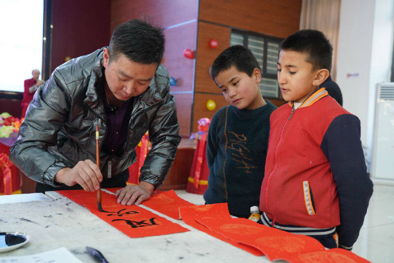 图为小朋友们聚精会神地欣赏书法家创作(吴旭庆 摄)