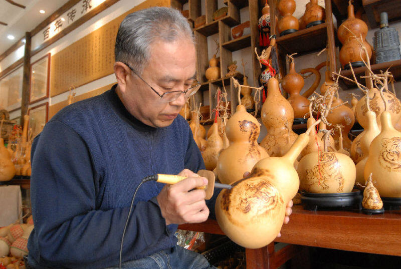 1月21日，黄旭在葫芦上运用烙画传统技艺烙出虎年生肖的吉祥图案，迎接新春佳节。（张涛 摄）