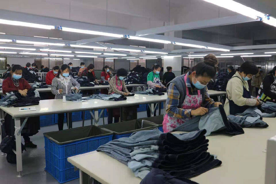 永鼎服饰公司的工人们加班加点赶做牛仔服(费琪琪 摄)