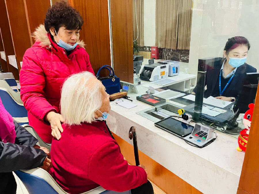 图为刘大娘在呼图壁农商银行营业部办理已故人员小额存款继承业务