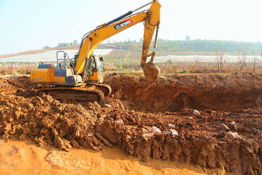 图为工人们利用挖机拓宽河道(赵树龙 摄)
