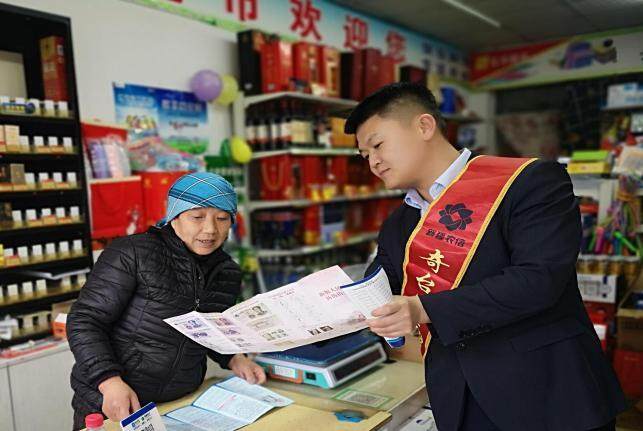 图为奇台农商银行工作人员向个体工商户宣讲金融政策。（罗娜 摄）