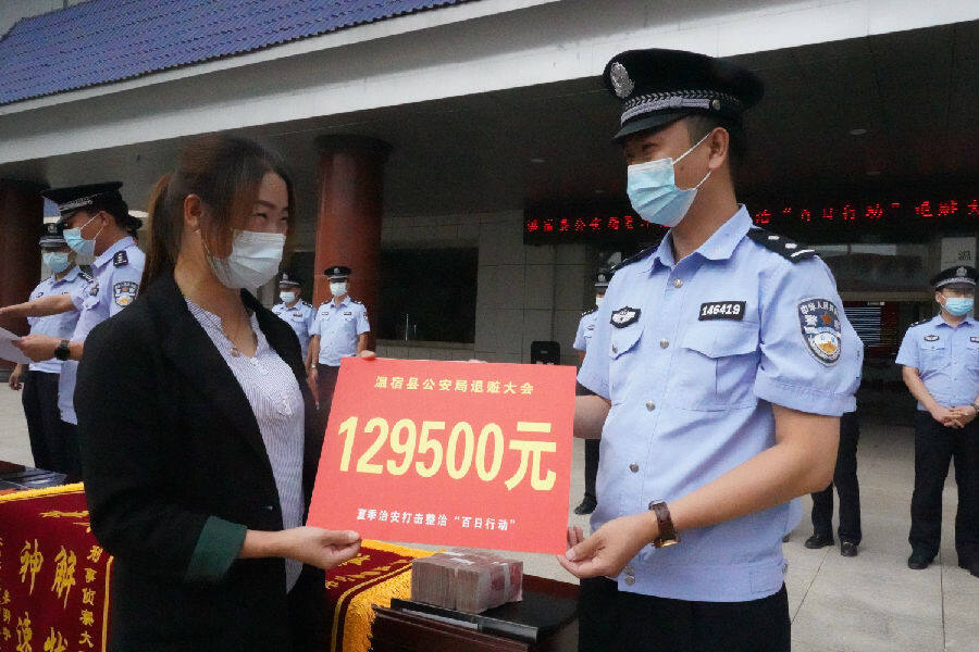 图为民警为受害人退还赃款129500元(张君森 摄)