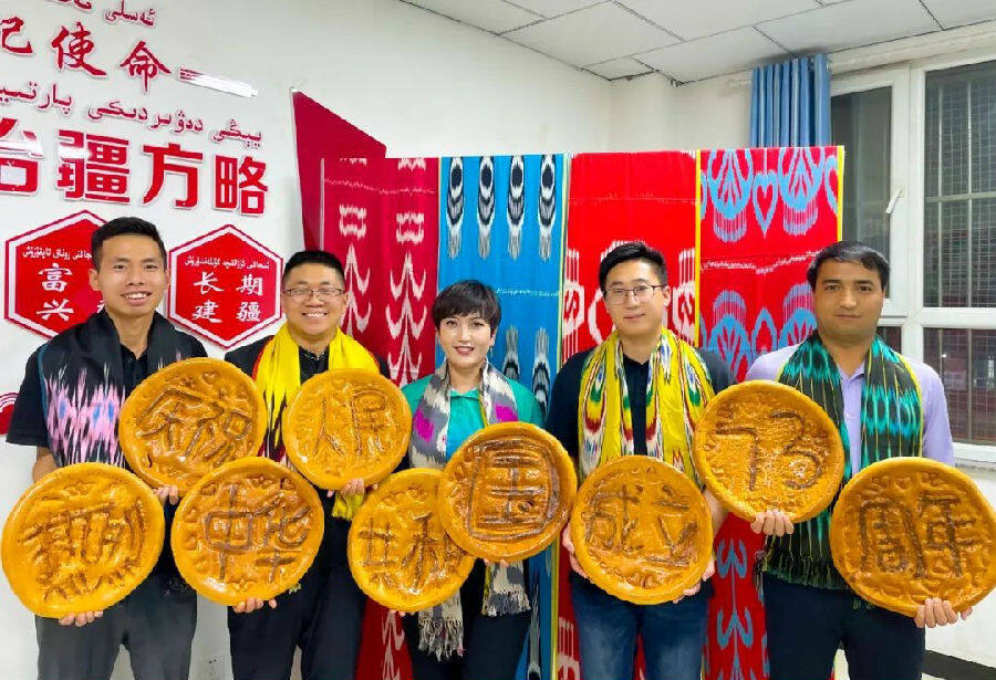 图为洛浦县杭桂镇机关干部制作“国庆馕”，热烈庆祝中华人民共和国成立73周年。（古丽米热·麦麦提江 摄）