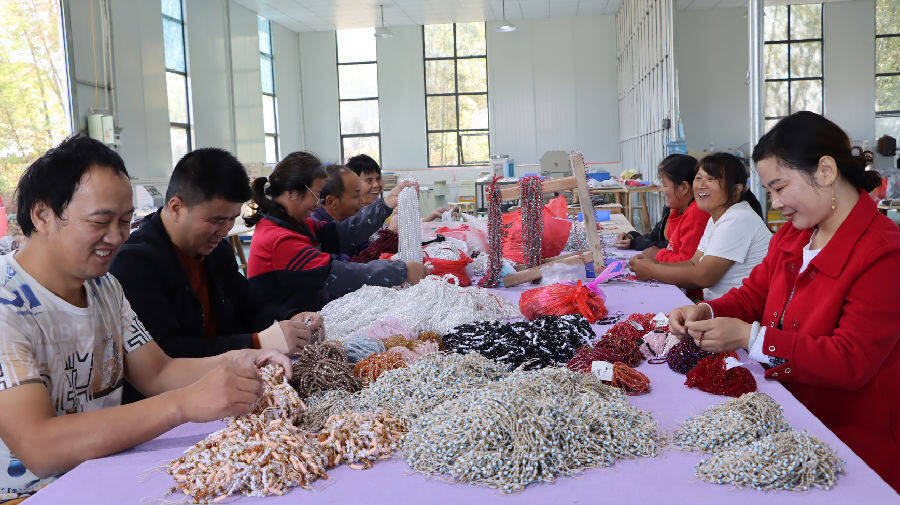 在燃湖村鴻盛飾品來料加工廠，工人們愉快地忙碌著。（劉存文 攝）