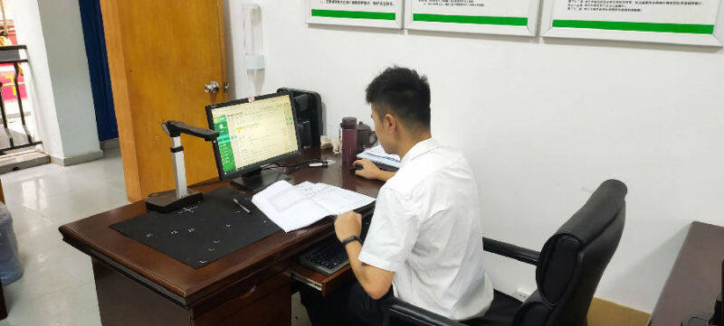 圖為浦北縣局小江管理所專賣員在對案件文書進行系統錄入（黃子峻 攝）
