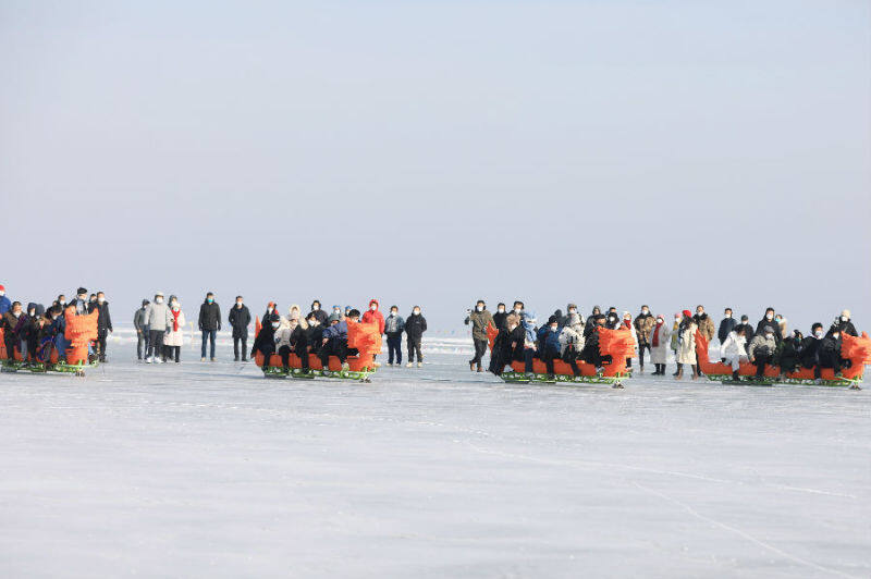 圖為游客們參與冰上劃龍舟比賽（胡侍琦 攝）