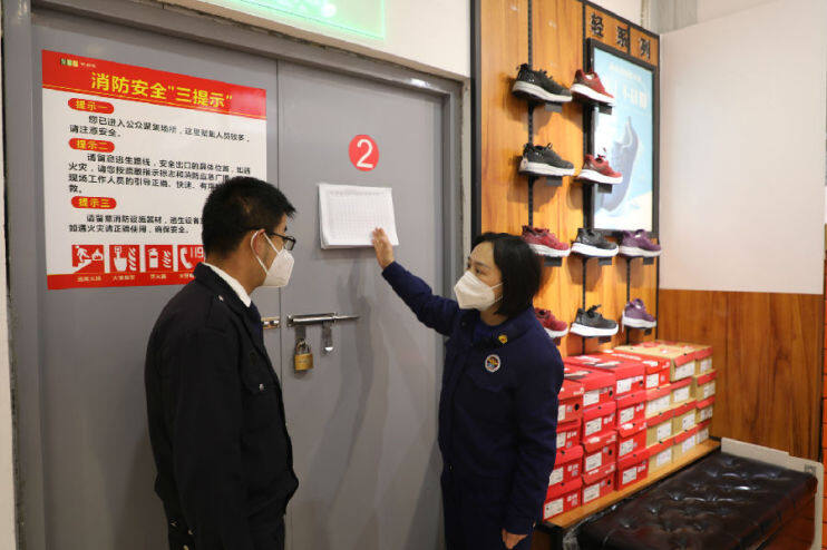 宣传人员对超市消防安全巡查资料填写进行指导（张平乐 摄）
