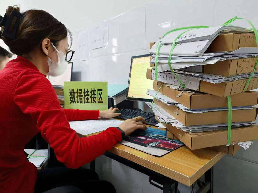 图为工作人员正在对纸质档案进行数据挂接(房诗浩 摄)