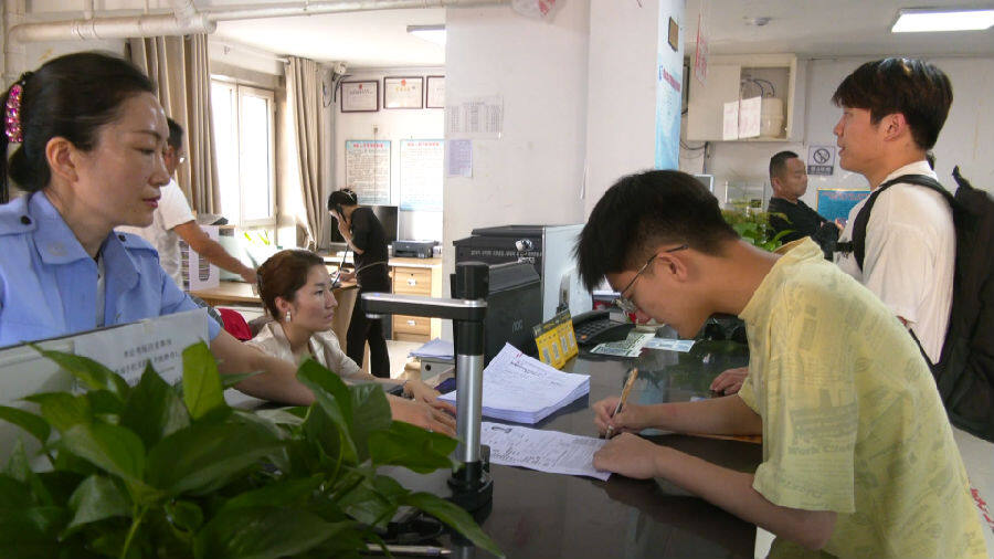 图为"准大学生"在驾校报名点排队报名(陈九洲 摄)