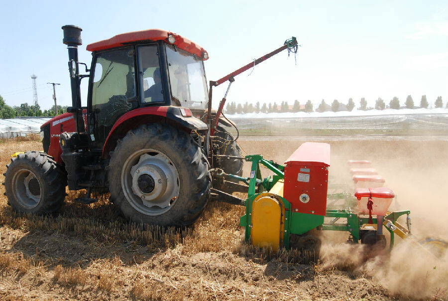 山东省青岛市即墨区移风店镇黄戈庄村农民驾驶拖拉机在播种玉米.