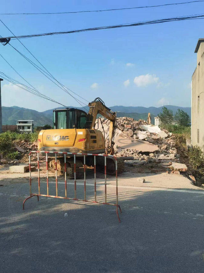 图为挖掘机正在实施拆迁(倪胜林 摄)