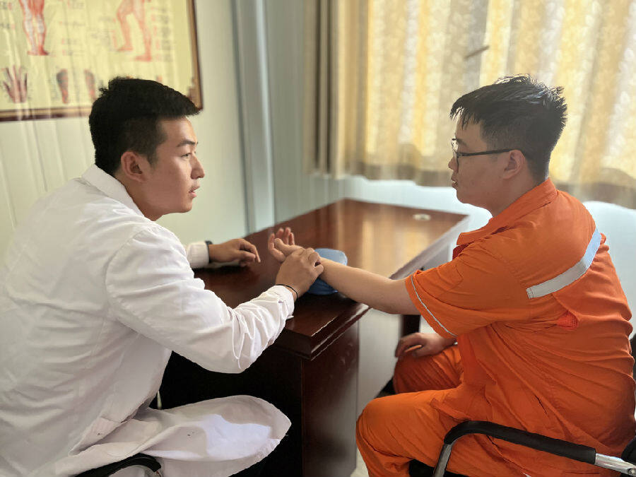 图为大石峡医务中心医生为职工把脉中(胡墨宸 摄)