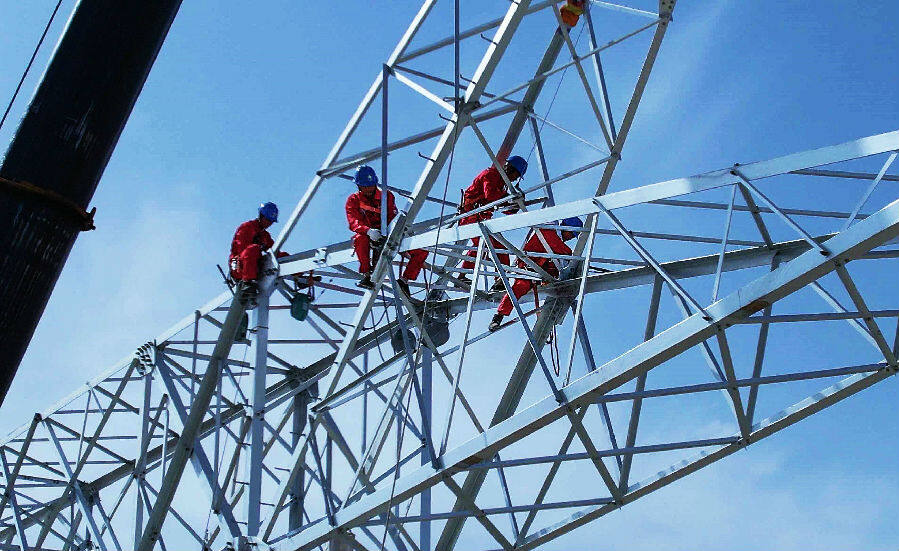 巴州—铁干里克—若羌750千伏输电线路工程作业人员在铁塔上安装塔材