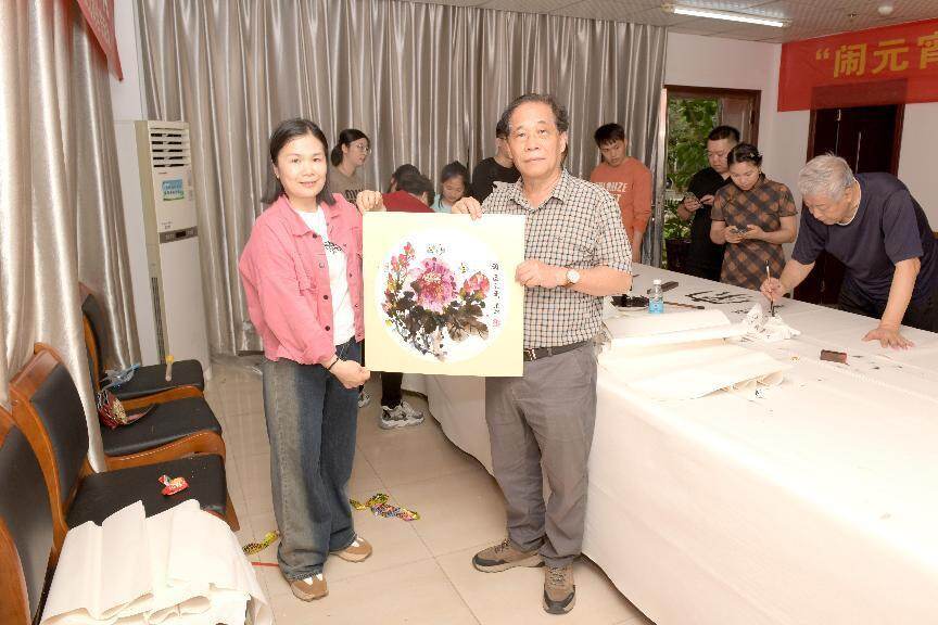 张建雄(右)赠送国画《国色天香》(吴太能 摄)海南省能源协会成立以来