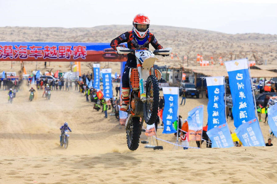图为沙漠越野拉力赛比赛现场 (年磊 摄)场内车手赛得激烈,场外观众看