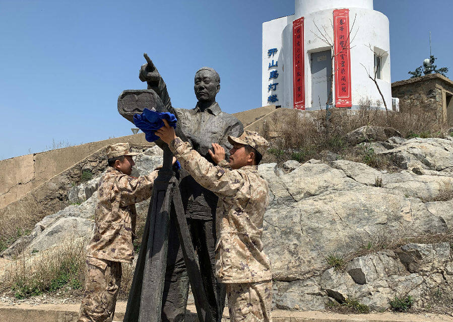 守岛民兵擦拭王继才铜像(陈万红 摄)