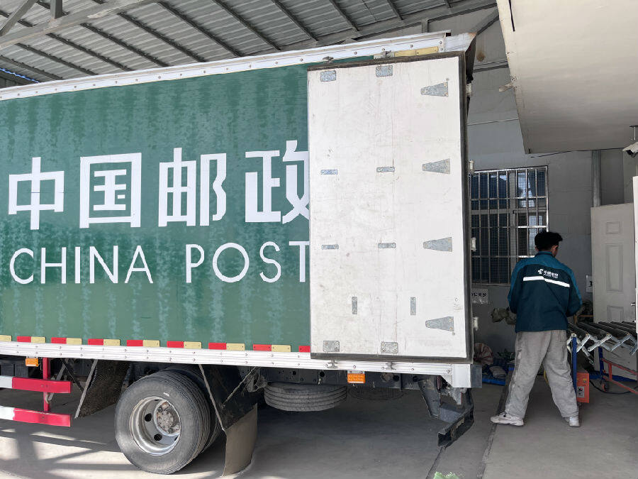 摄)在和硕县中国邮政物流园,装满快递的运输车早早到达园内,一件件