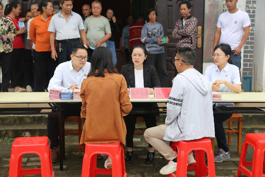 圖為法律宣傳志愿者在曹里村現場為村民開展法律咨詢服務（吳昊 攝）