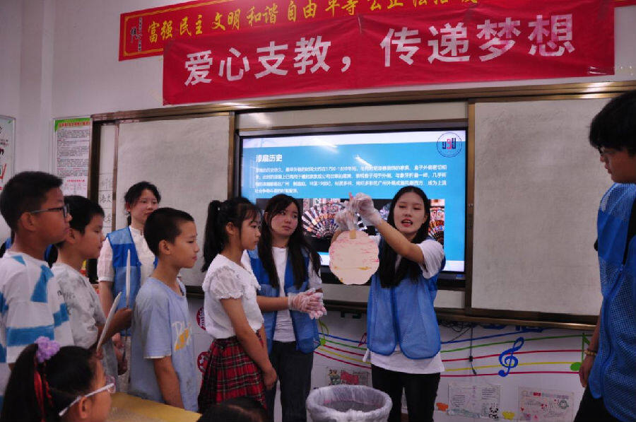图为武汉晴川学院计算机学院支教志愿者为孩子们讲解漆扇制作要领（黄安东 摄）