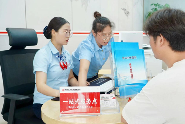 银行工作人员和市场监督管理局工作人员合力为客户办理首笔营业执照在线申请业务 （田力 摄）