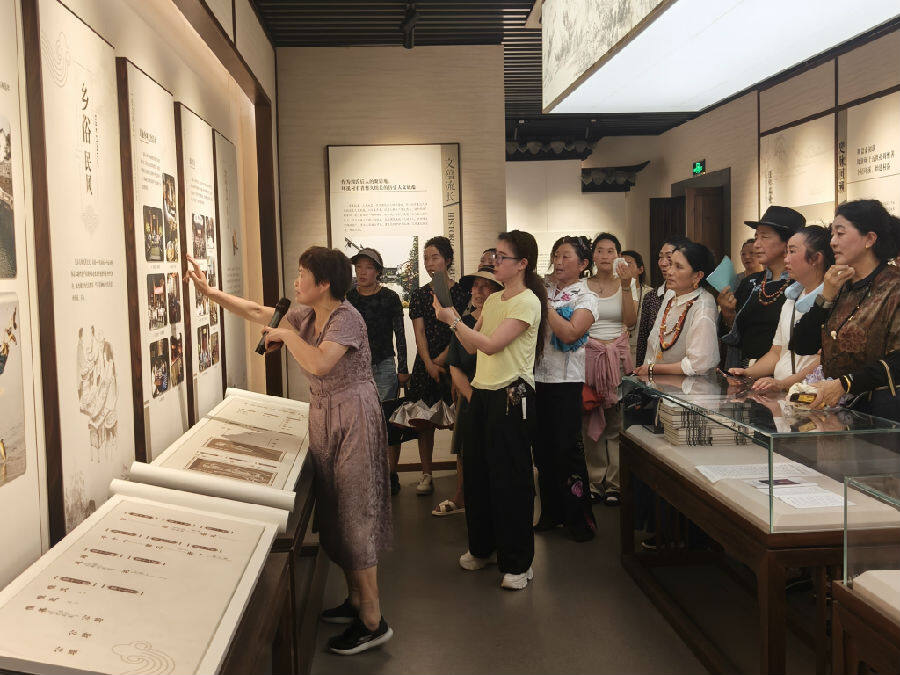 在环溪村村史馆周忠莲（左一）介绍村庄由脏乱差到美丽宜居示范村的蜕变过程（曾庆华 摄）