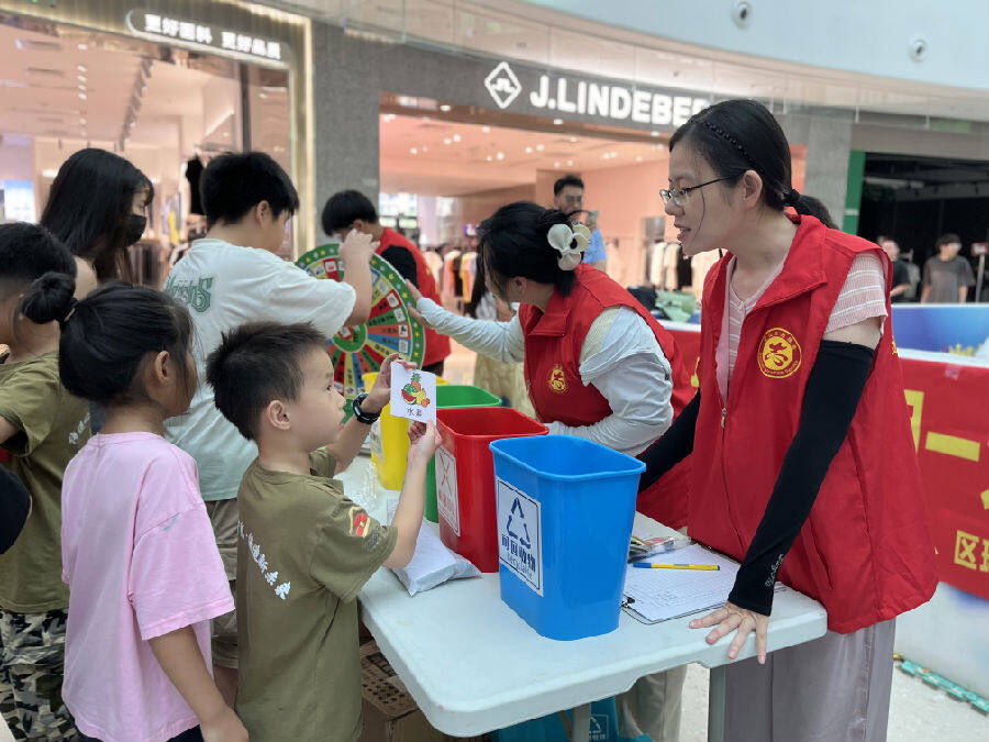 在现场，孩子们从玩乐中学习垃圾分类的相关知识。（李美玲摄）