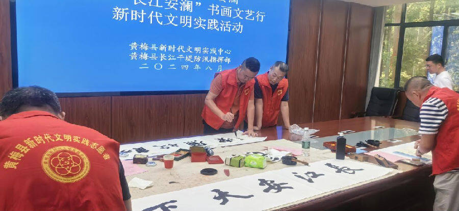 黄梅县当地书画爱好者深入防汛一线采风，并进行主题创作现场。（张志林 摄）