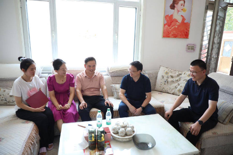 工作人员在给学子送奖学金时了解开学准备情况（张南宁 摄）