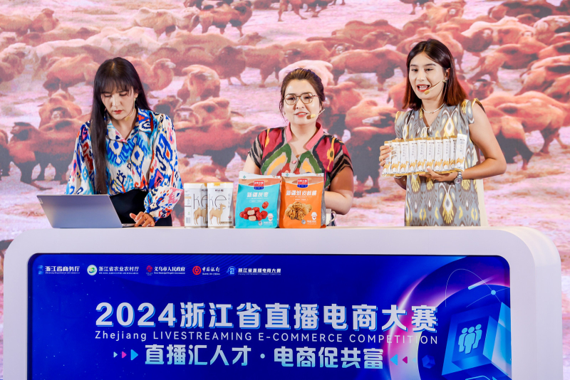 “精致柯坪”团队身着民族服饰，热情洋溢地展示了柯坪驼奶粉、黄杏、恰玛古等特色农副产品。（艾克拜尔 摄）