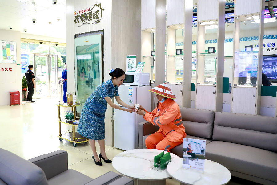网点工作人员关爱户外劳动者（牙玉珮 摄）