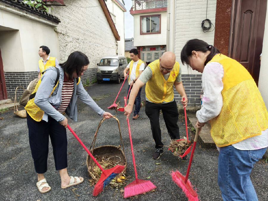 图为桂林烟草志愿者到灵川县潭下镇山口村开展卫生清扫活动（李茜 摄）
