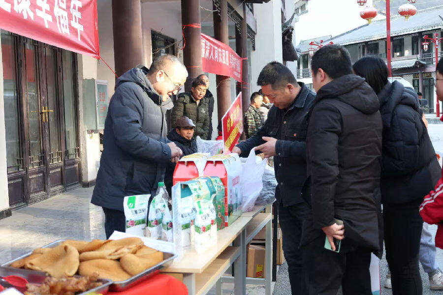 非遗美食、农特产品展位前围满了购买年货的群众（邹景根 摄）