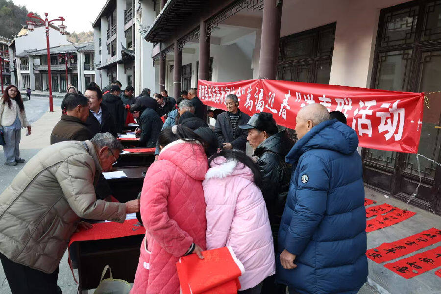书法爱好者提笔为群众写春联（邹景根 摄）