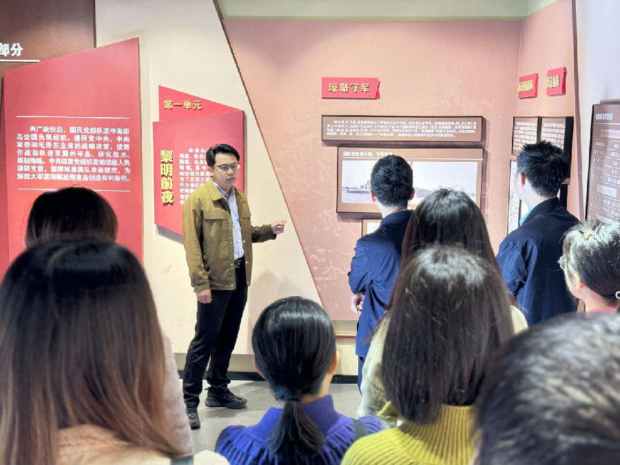 吴不达（左三）向游客讲解解放海南岛琼西接应指挥部旧址历史（王朝坚 摄）