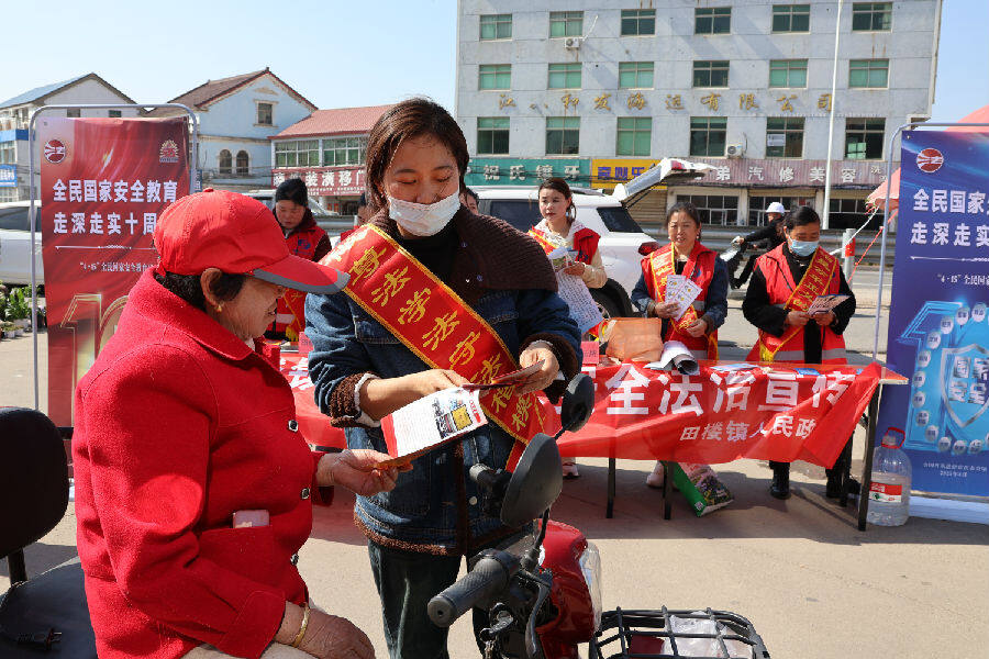 网格员们将一份份宣传册递到居民手中（王华 摄）