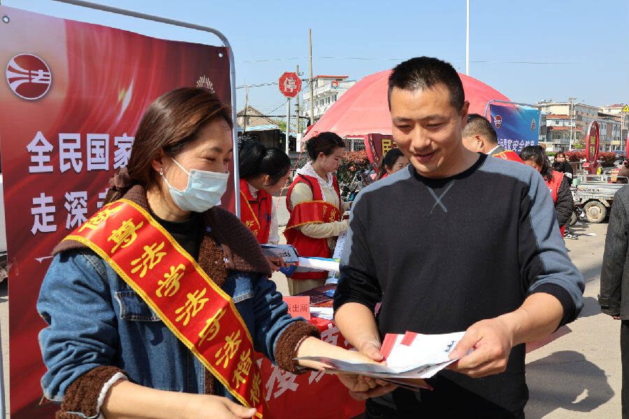 网格员们将一份份宣传册递到居民手中（王华 摄）