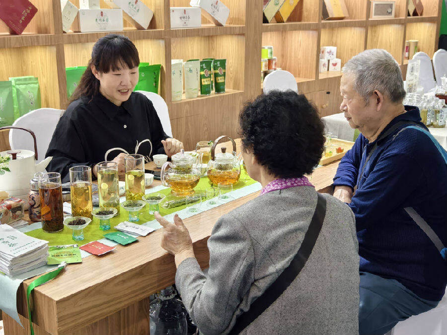 茶博会广元展馆内一对老年夫妇咨询青川白茶（戚译升 摄）