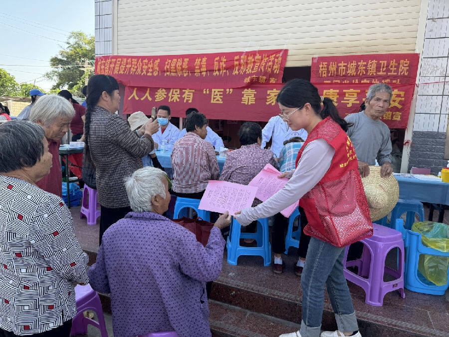 志愿者在河口村向村民派发移风易俗宣传册（吴炫菲 摄）