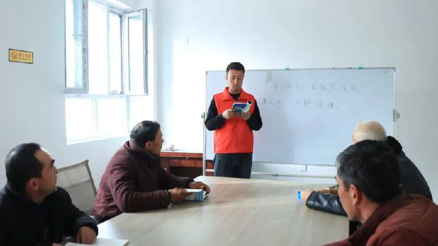 耐心地教几位农牧民组词造句（艾克拜尔 摄）
