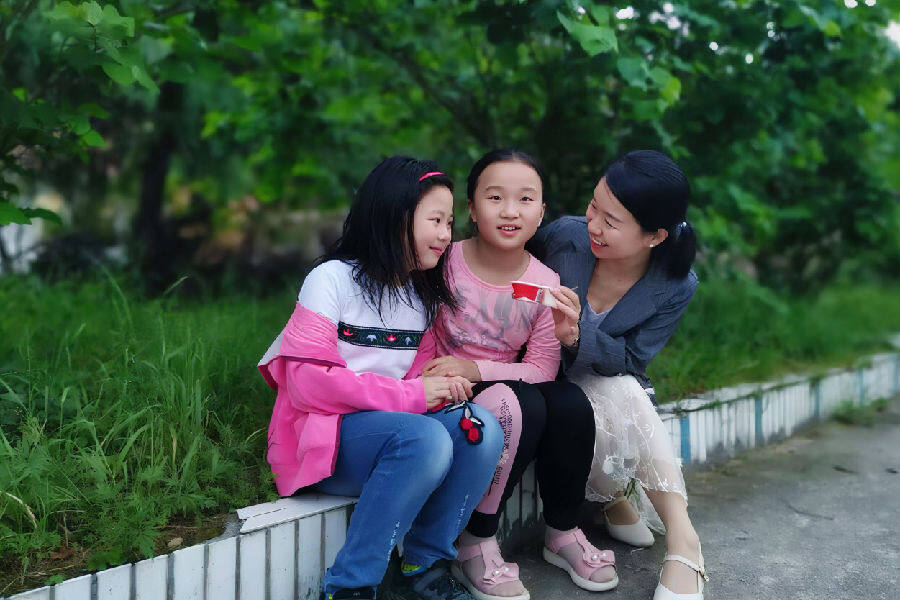 彭美丹和孩子们在一起（王定禄 摄）