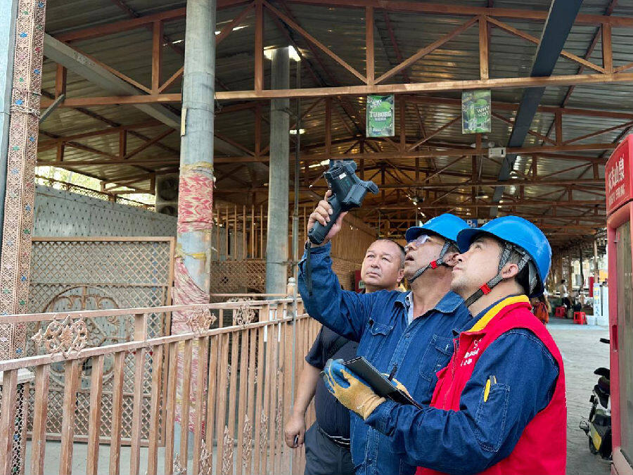 工作人员对阿克苏老街夜市线路进行测温工作（邸敏 摄）