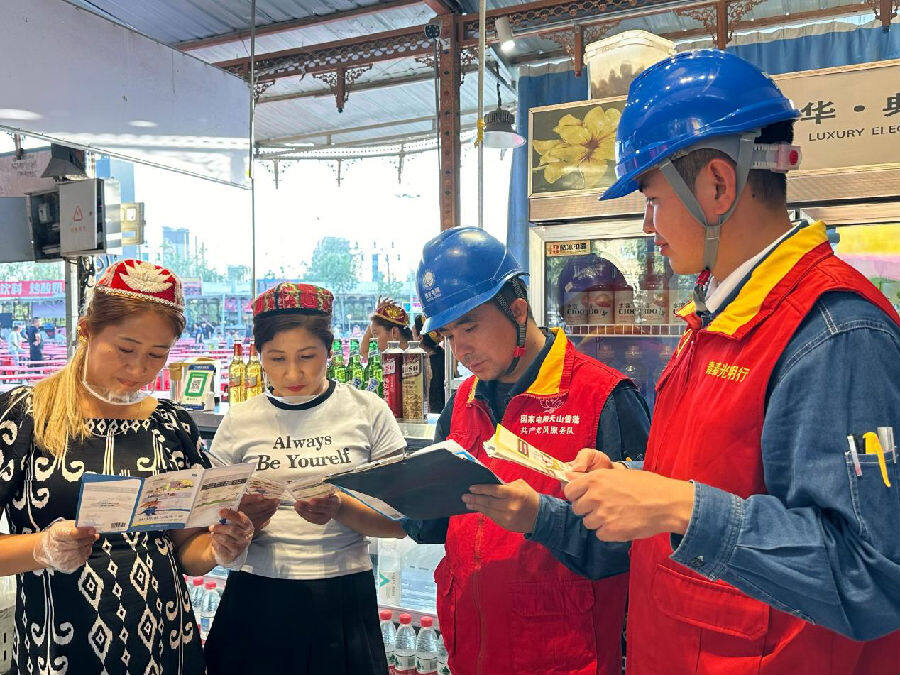 国网阿克苏市工作人员向商户进行安全用电及节能降耗讲解（邸敏 摄）