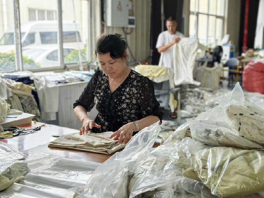  图为天门服装基地内工人正在进行打包（余惠玲 摄）